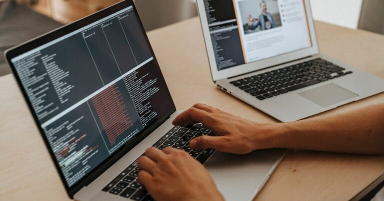 A developer working on a laptop, typing code, showcasing programming and technology skills.
