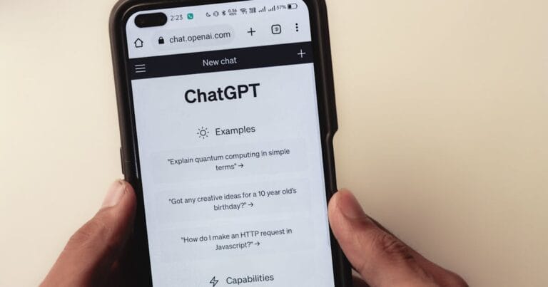 Close-up of hands holding a smartphone displaying the ChatGPT application interface on the screen.